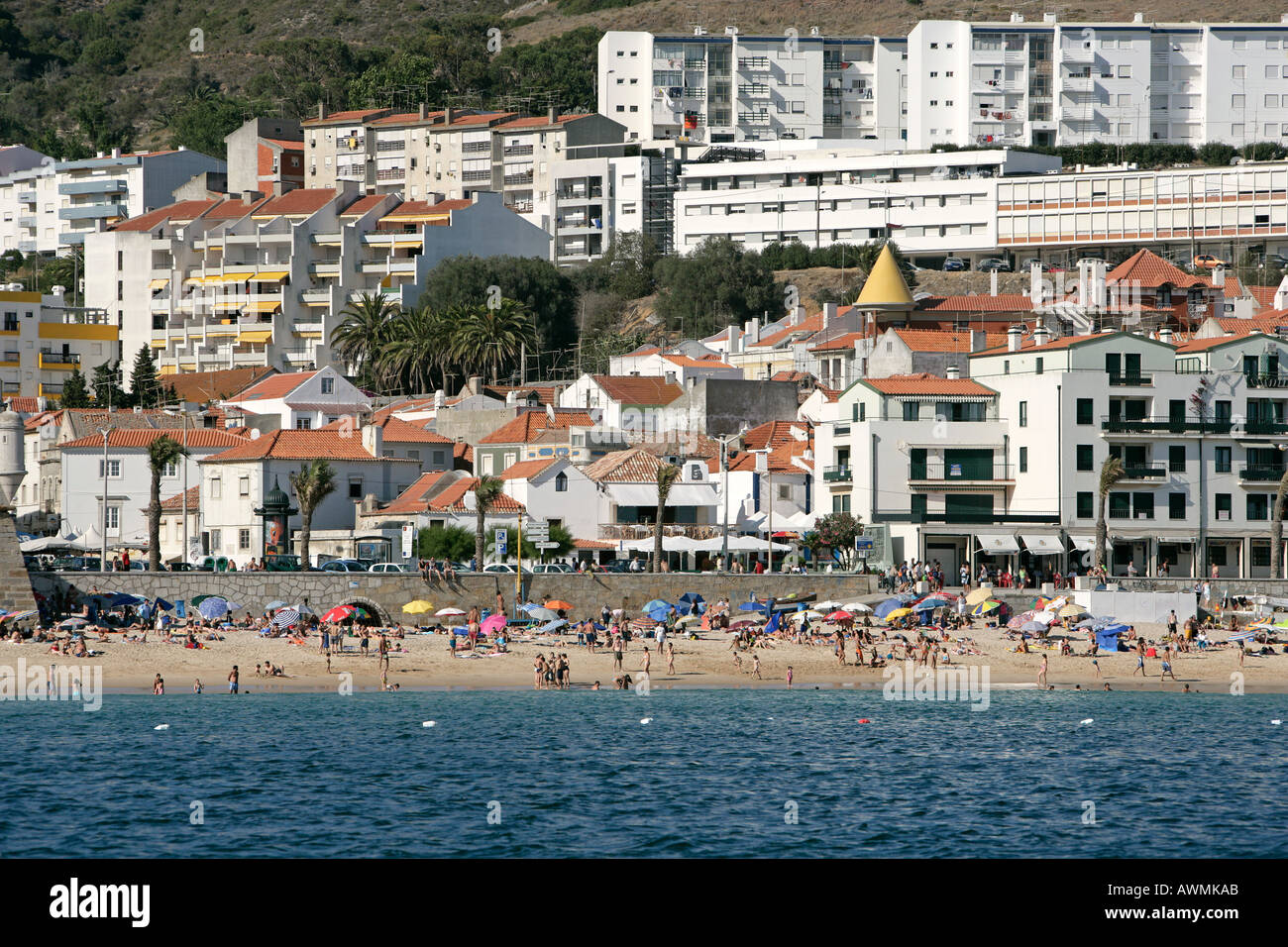Typical overbuilding on the beaches of Europe Here bathers crowd the beach in Sesimbra Portugal Stock Photo