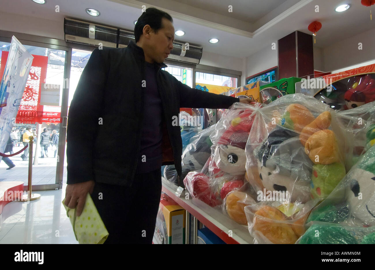 A shopper buys Olympic mascots at a shop in Beijings Wanfujing shopping district Stock Photo