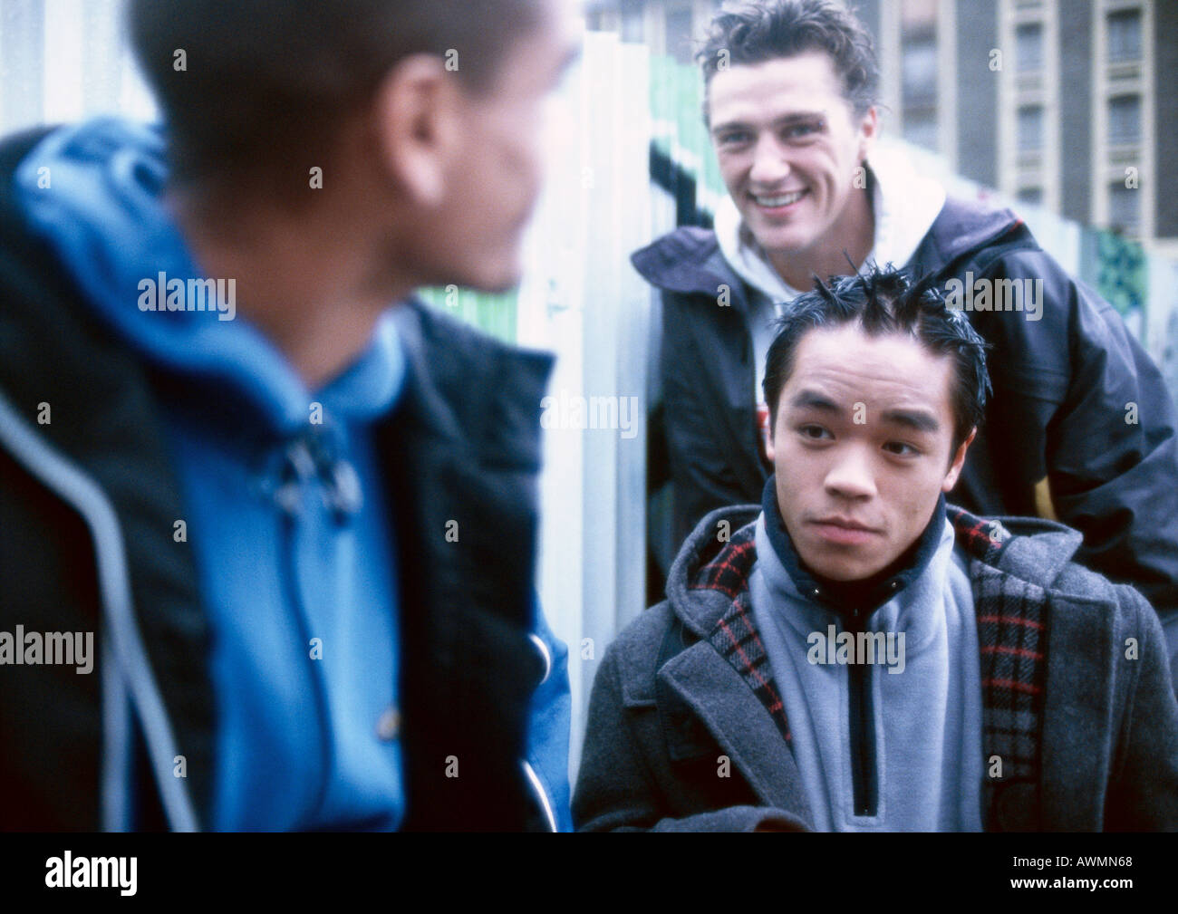 Three young men outside, building in background Stock Photo