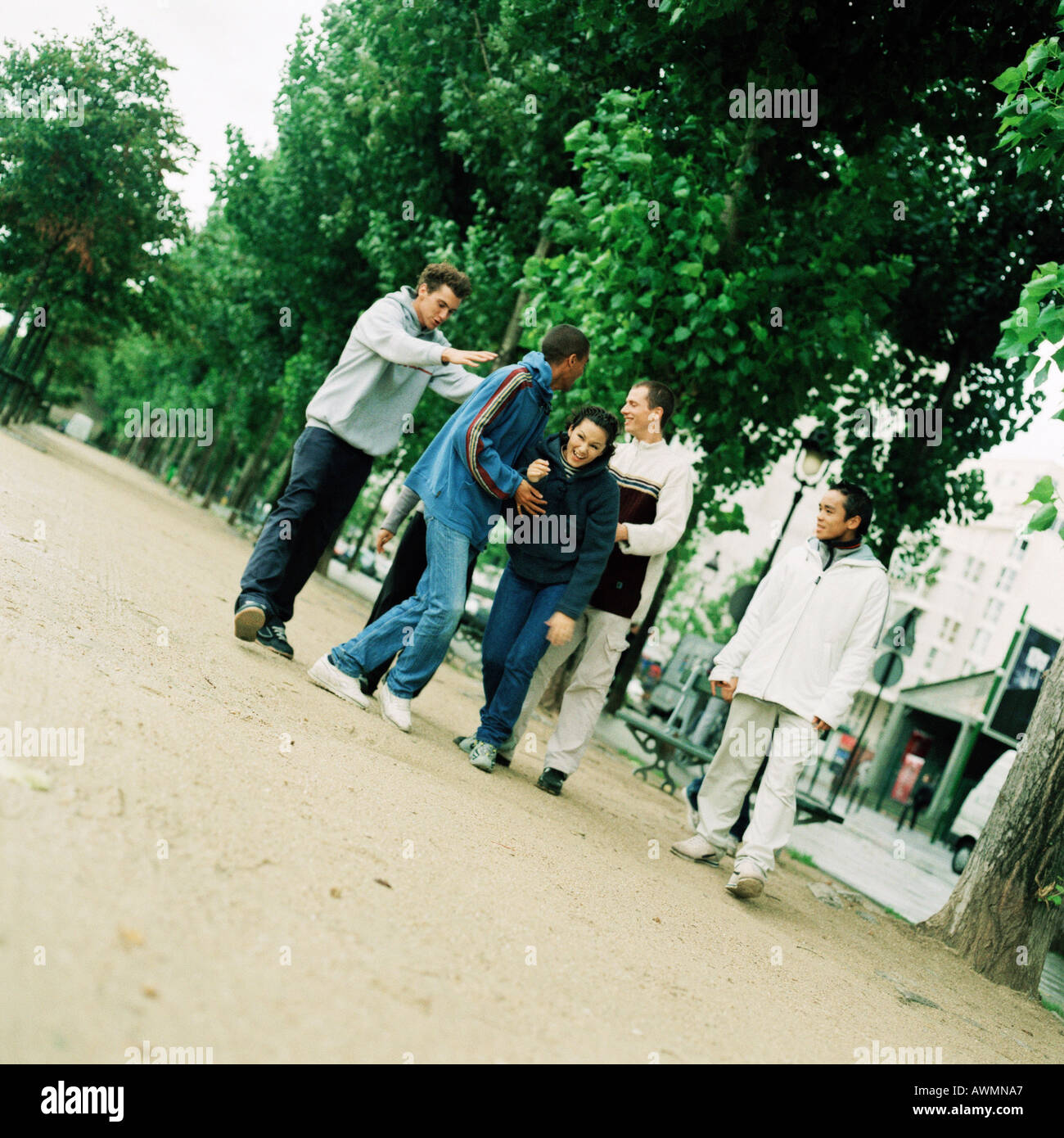 Group of young people walking in park Stock Photo - Alamy