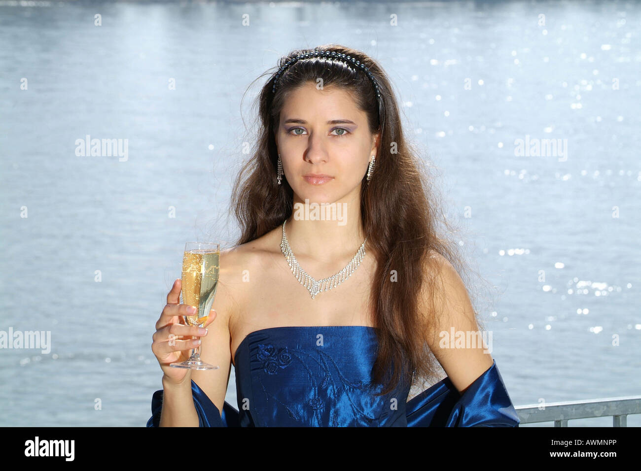Young woman in festive evening clothes with champagne glass in her hand Stock Photo