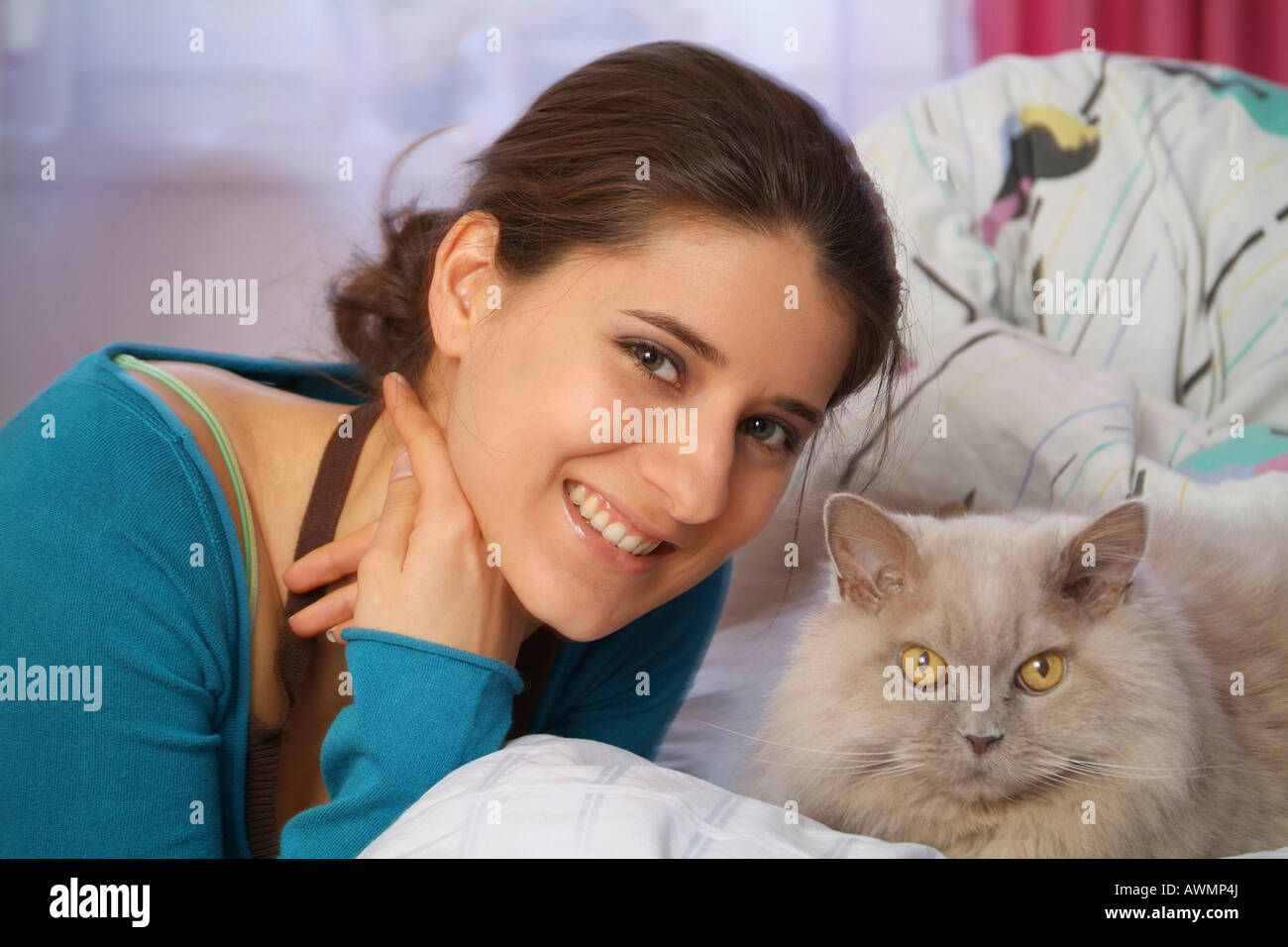 Young woman laying on bed with her cat Stock Photo