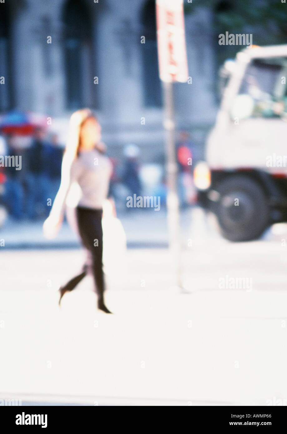 Woman holding bag, walking in street, blurred Stock Photo
