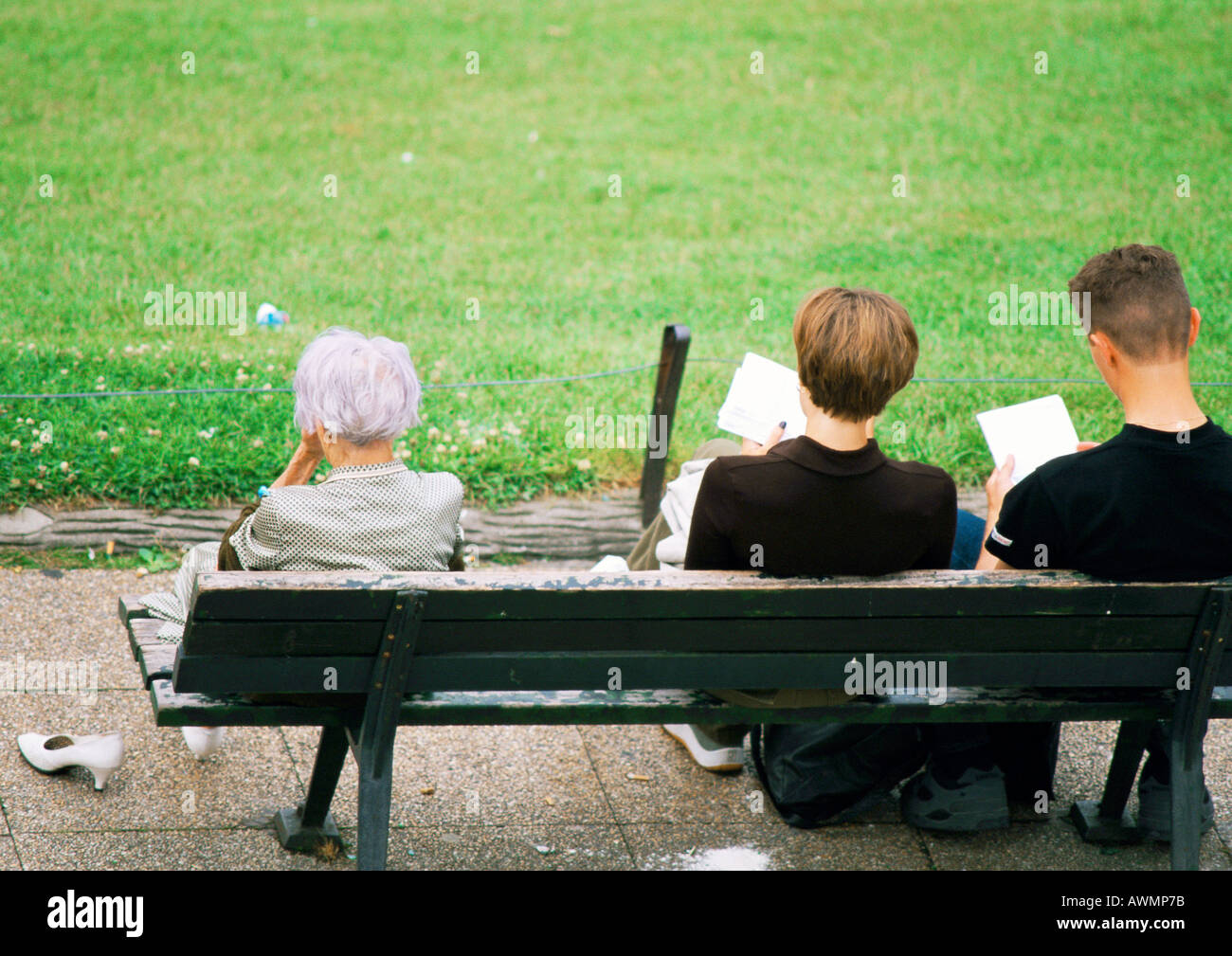 Three people sitting on bench, rear view Stock Photo