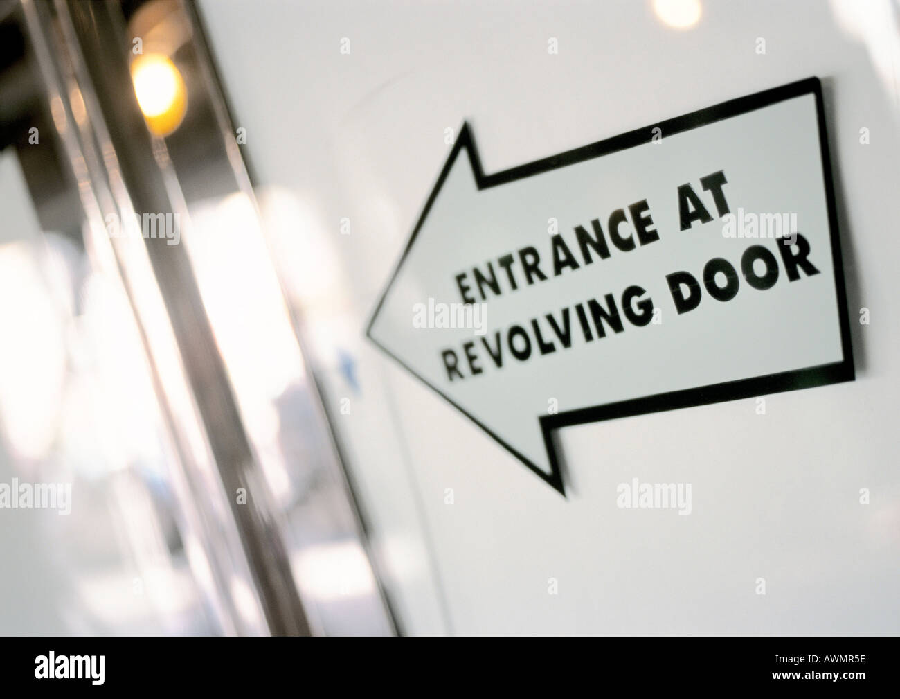 Entrance at revolving door text on arrow sign, close-up Stock Photo