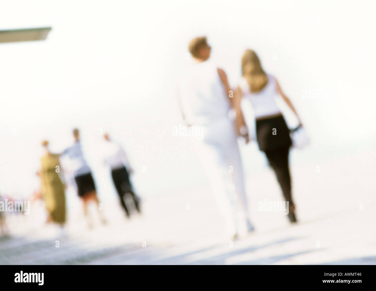 People walking along at beach, blurred Stock Photo