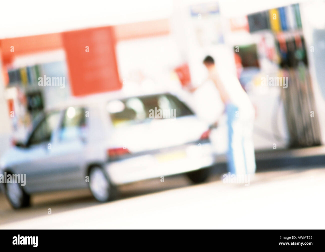 Person filling up car at gas station, blurred Stock Photo