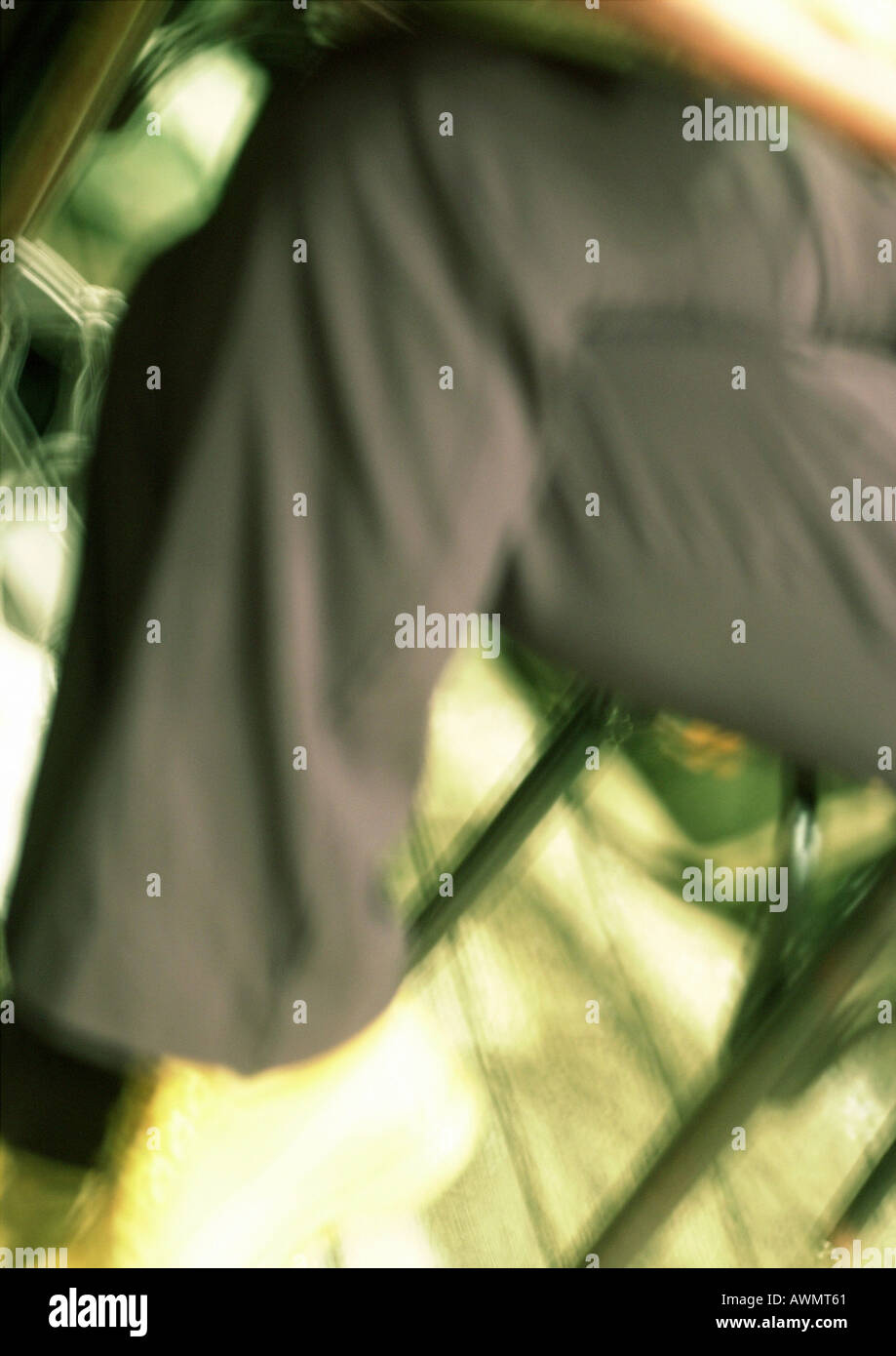 Man's crossed legs, blurred. Stock Photo