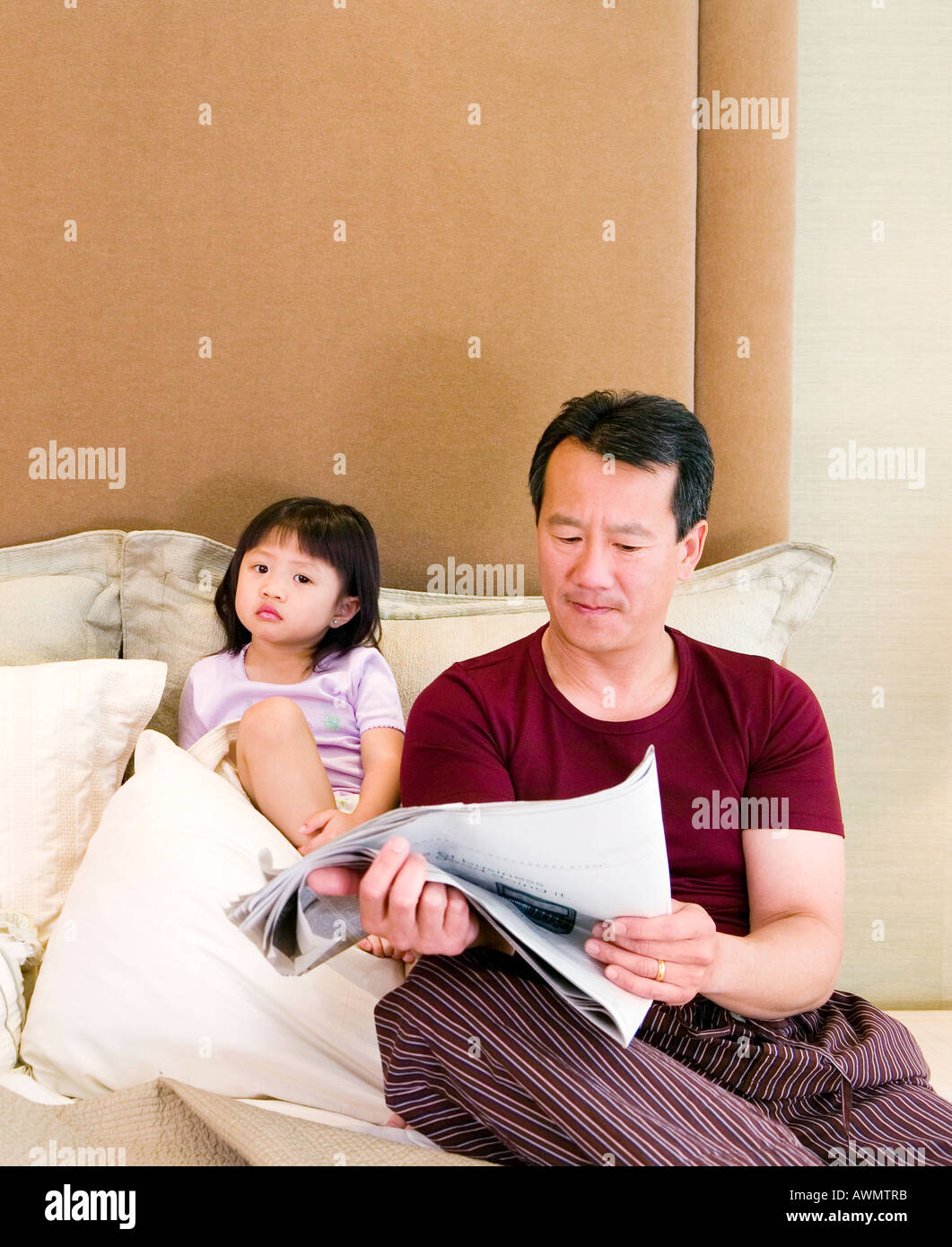 Asian father and daughter sitting in bed Stock Photo Alamy