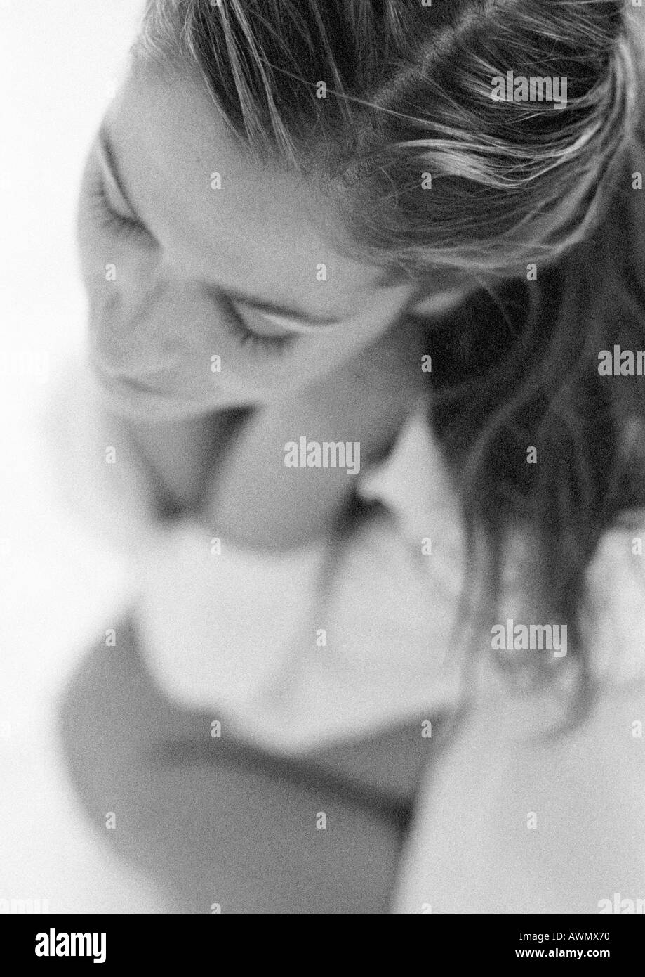 Woman sitting, focus on hair, high angle view, black and white. Stock Photo