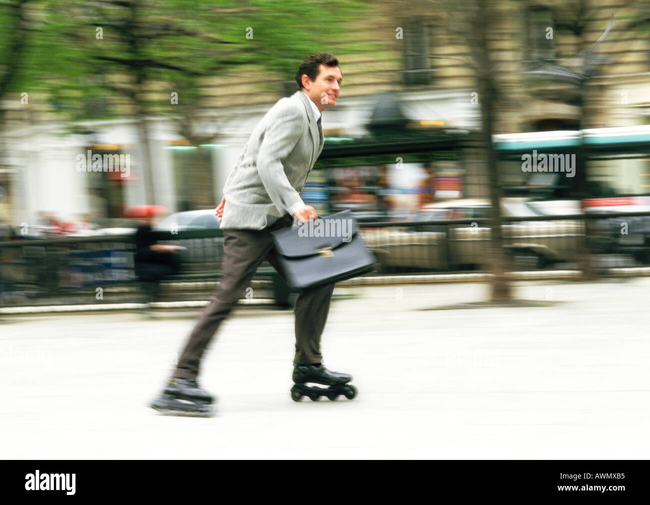 businessman-rollerblading-in-park-blurred-AWMXB5.jpg
