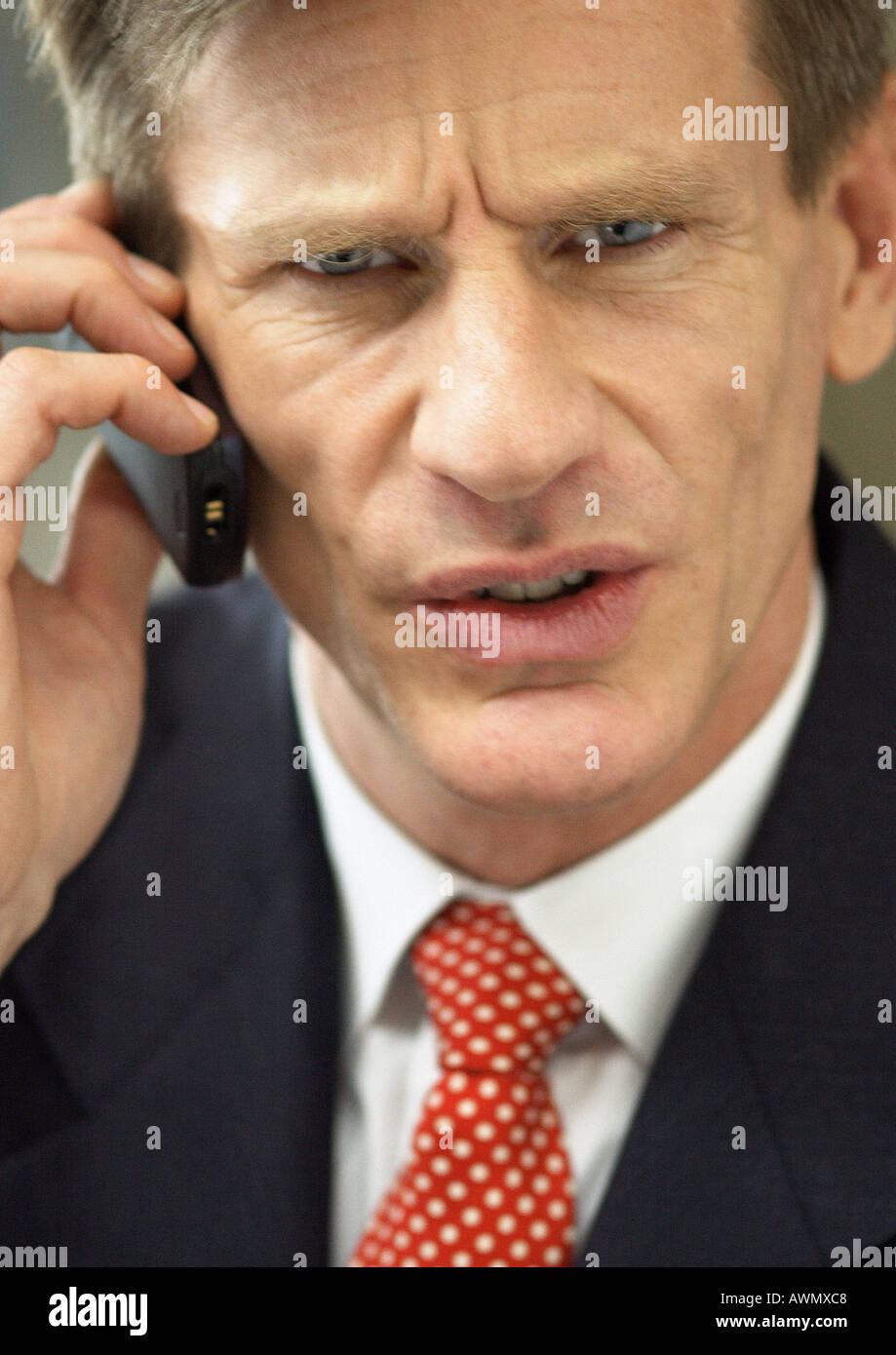Businessman using cellular phone, close-up portrait. Stock Photo