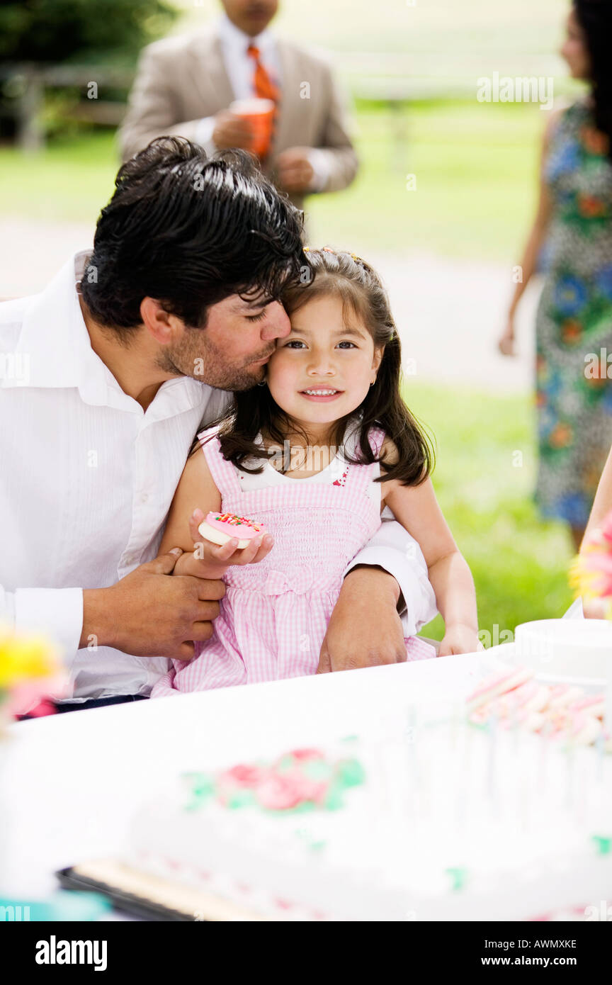 Hispanic father kissing daughter Stock Photo