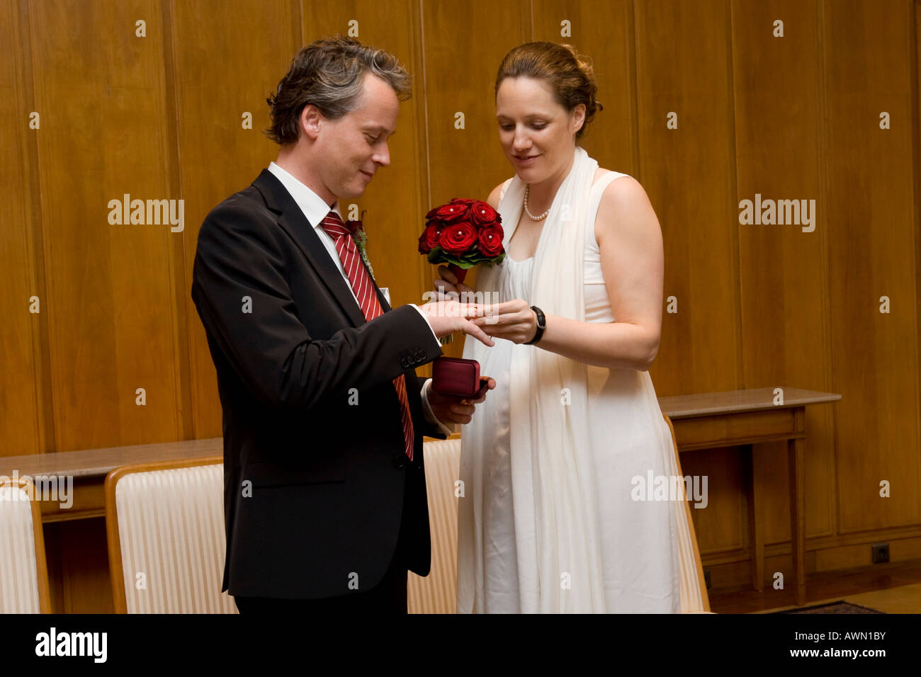 Newly married couple exchanging rings at Registrar's Office Stock Photo