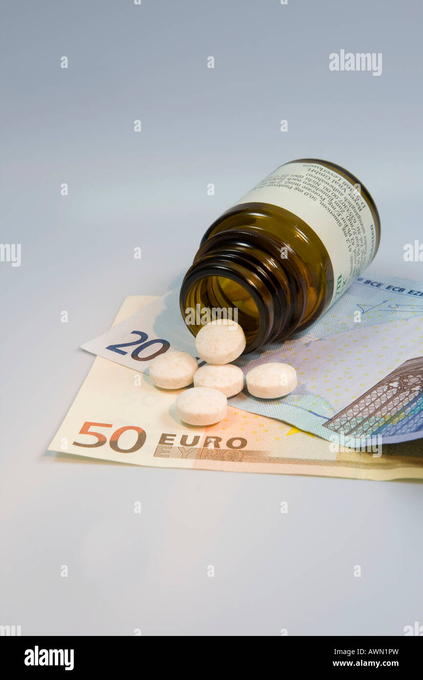 Prescription drugs are getting more expensive: pills tumbling from pill bottle onto Euro notes Stock Photo