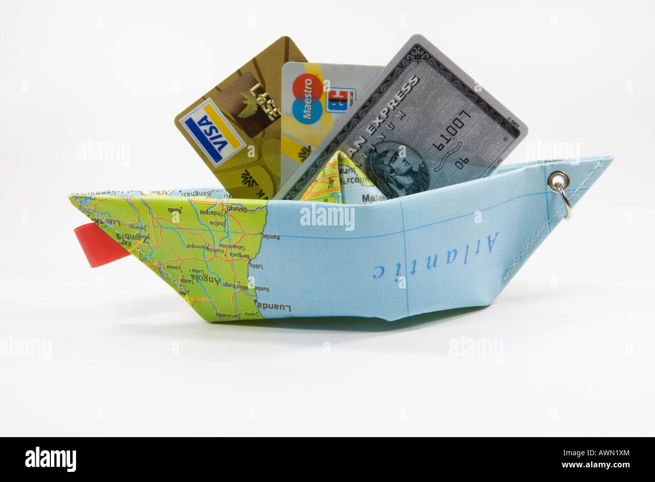 Credit cards and a paper ship made from a map: symbol for payment methods while travelling Stock Photo