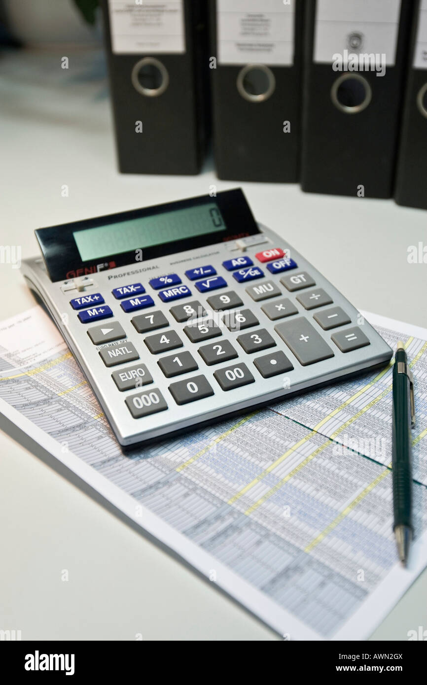 Calculator and a pencil laying on top of a list of numbers, binders in