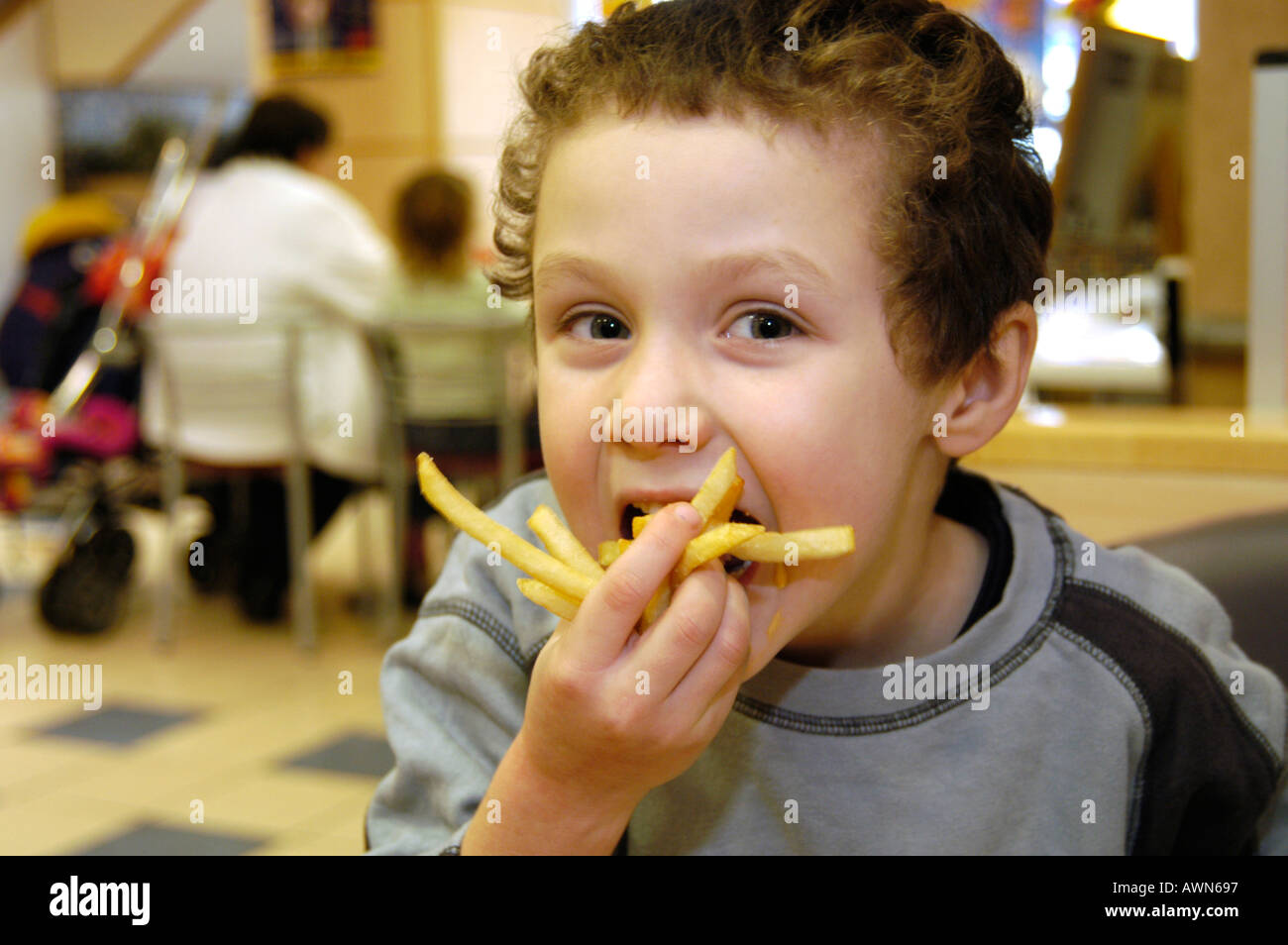 Small boy eating Mcdonald's French fries, England, UK Stock Photo