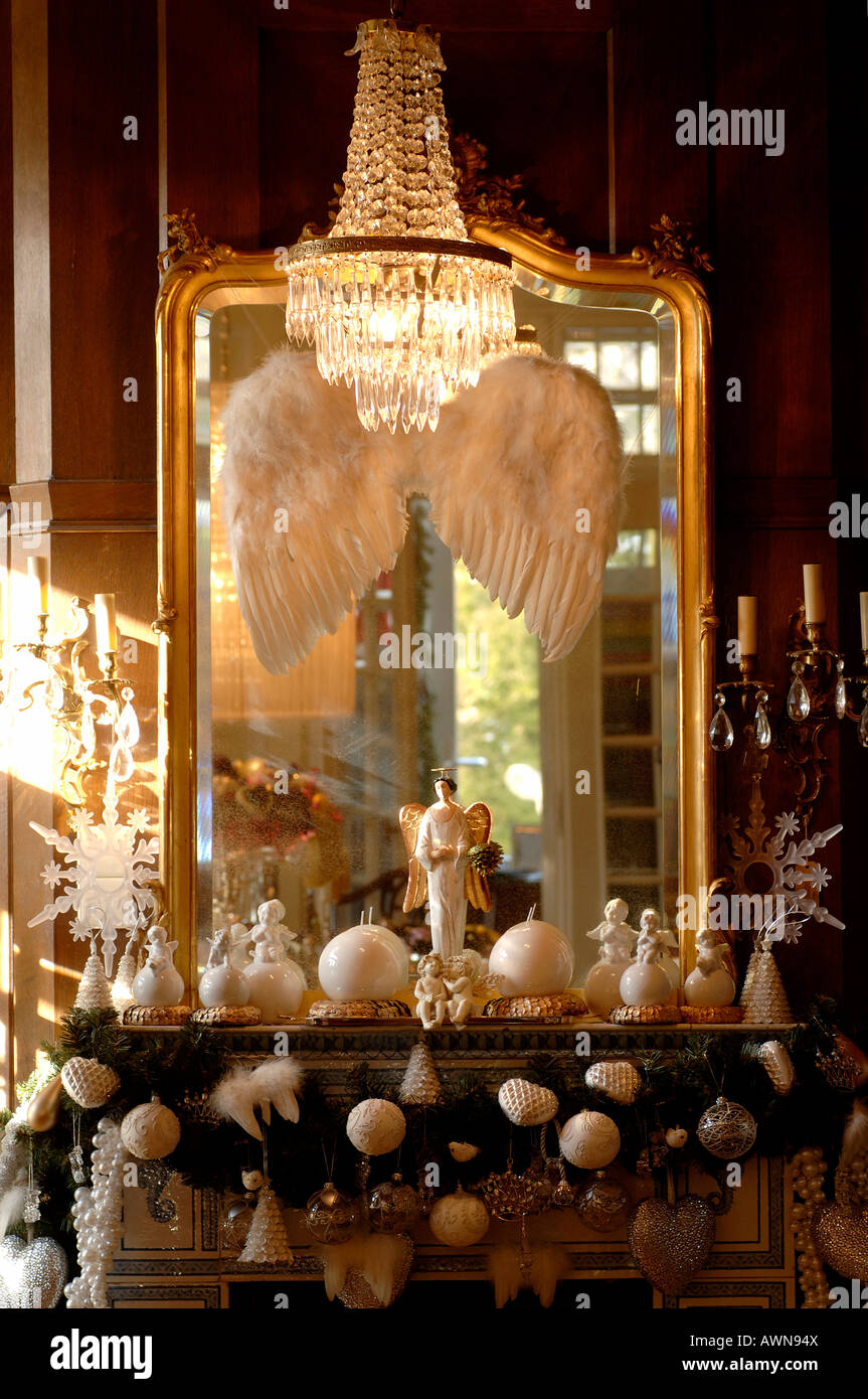 Mantle decorated for Christmas: silver ornaments in front of a gold-framed mirror, chandelier Stock Photo