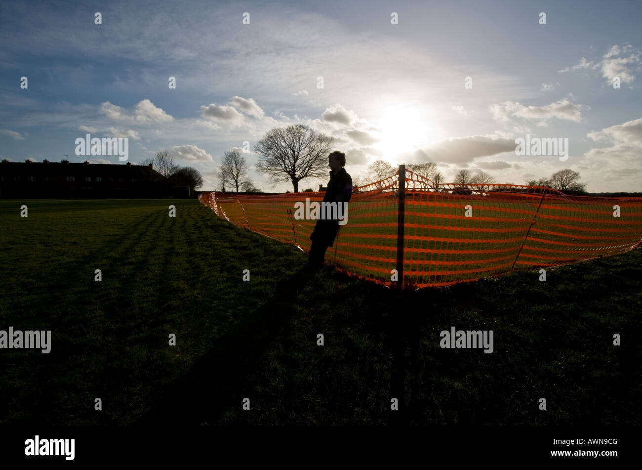 young boy on recreation ground with sun and silhouette Stock Photo