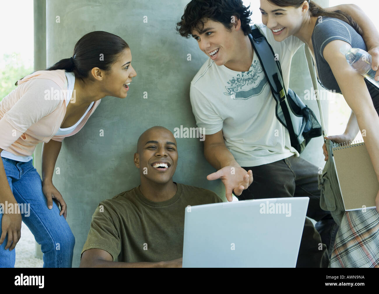 College students looking at laptop and laughing Stock Photo