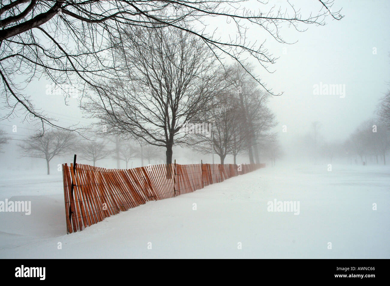 Blizzard snow conditions create a winter scenic along a snow fence in Port  Huron Michigan during winter time Stock Photo - Alamy