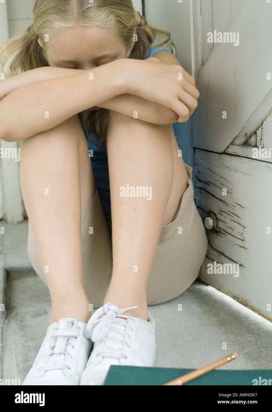 Girl sitting with knees up and head down Stock Photo Alamy