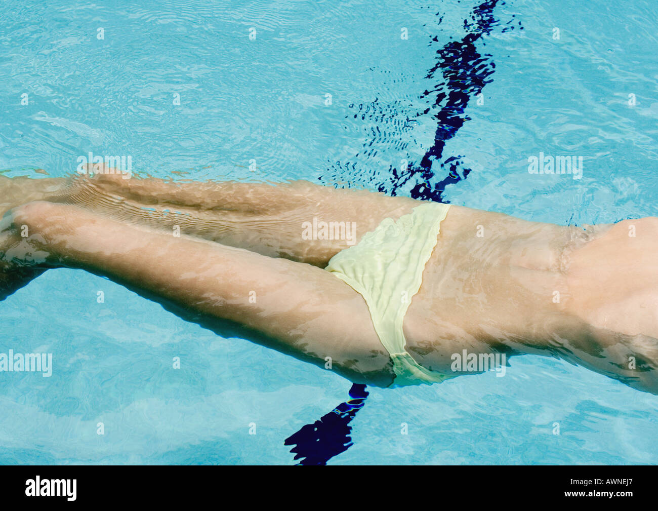 Woman floating on back in pool, mid section Stock Photo