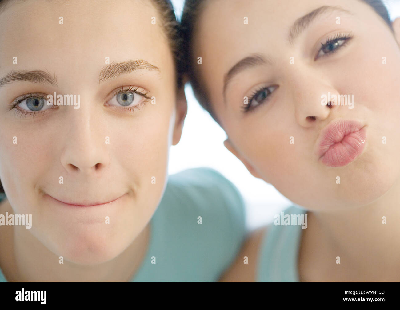 Two preteen girls, one puckering, the other pursing lips Stock Photo