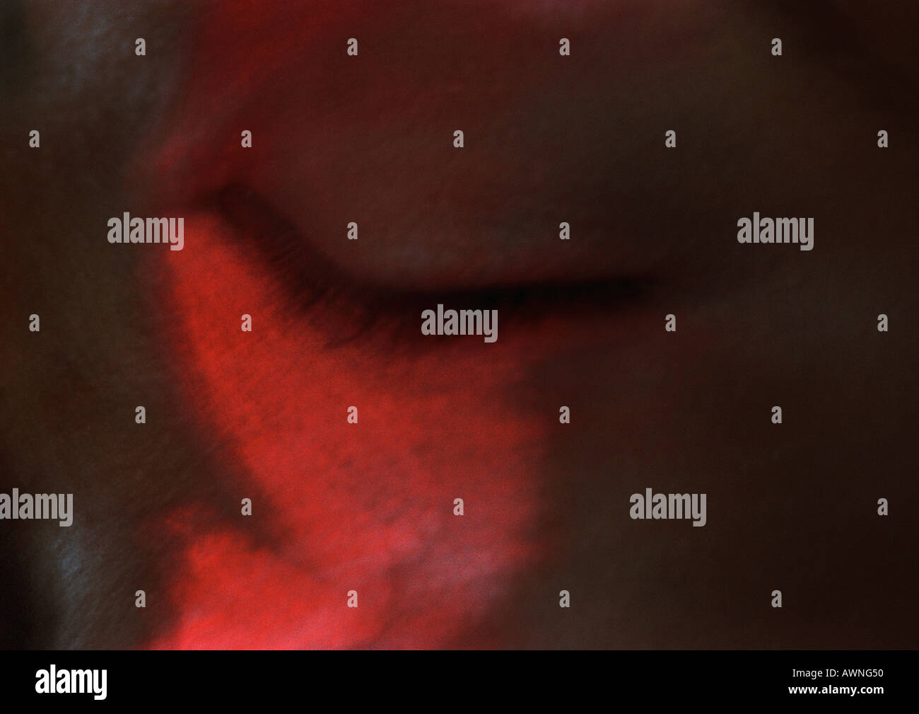 Woman's eye closed, red on face, blurred close up. Stock Photo