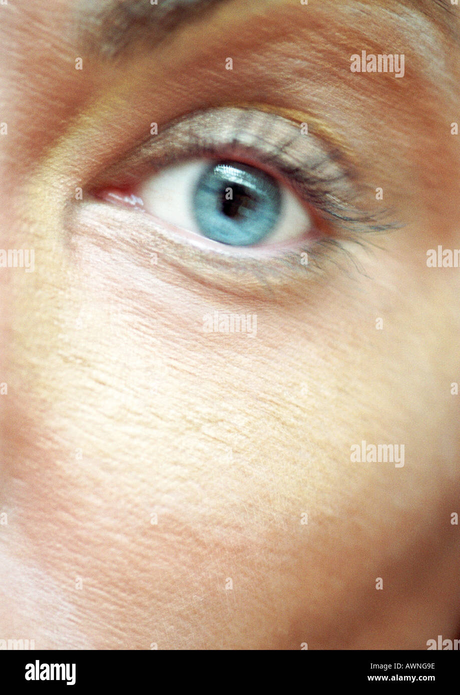 Woman's blue eye, looking at camera, blurred close up. Stock Photo