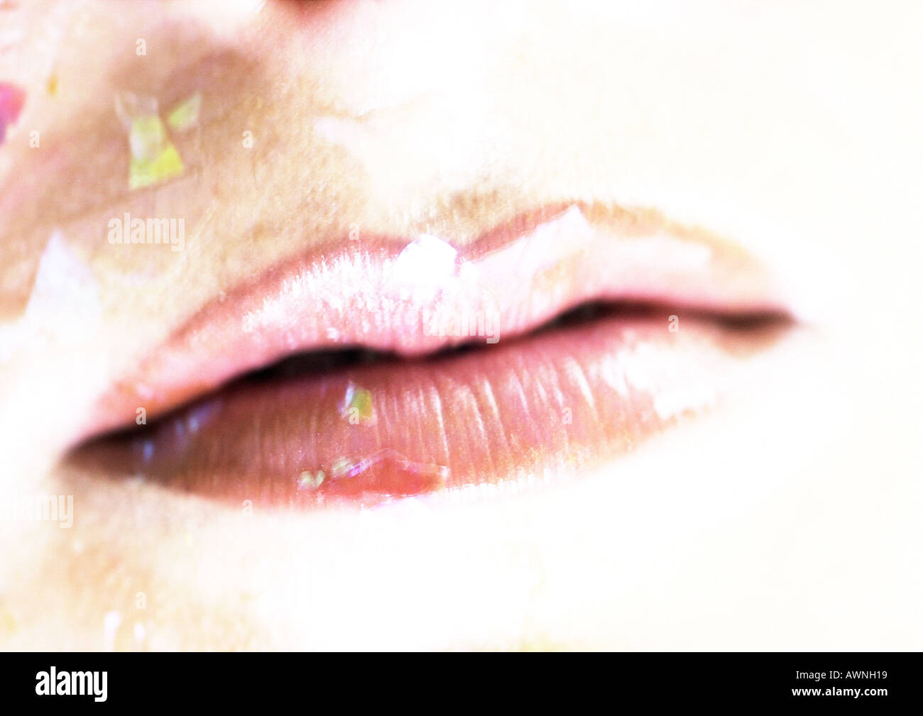 Woman wearing pink lipstick, close up of mouth with confetti. Stock Photo