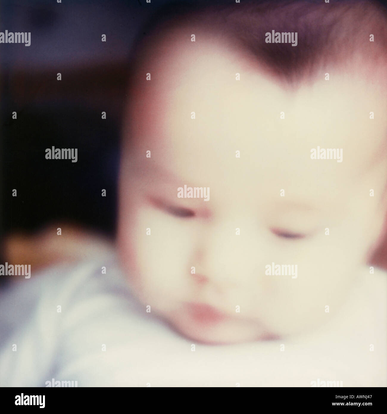 Baby looking down, close-up, blurred. Stock Photo