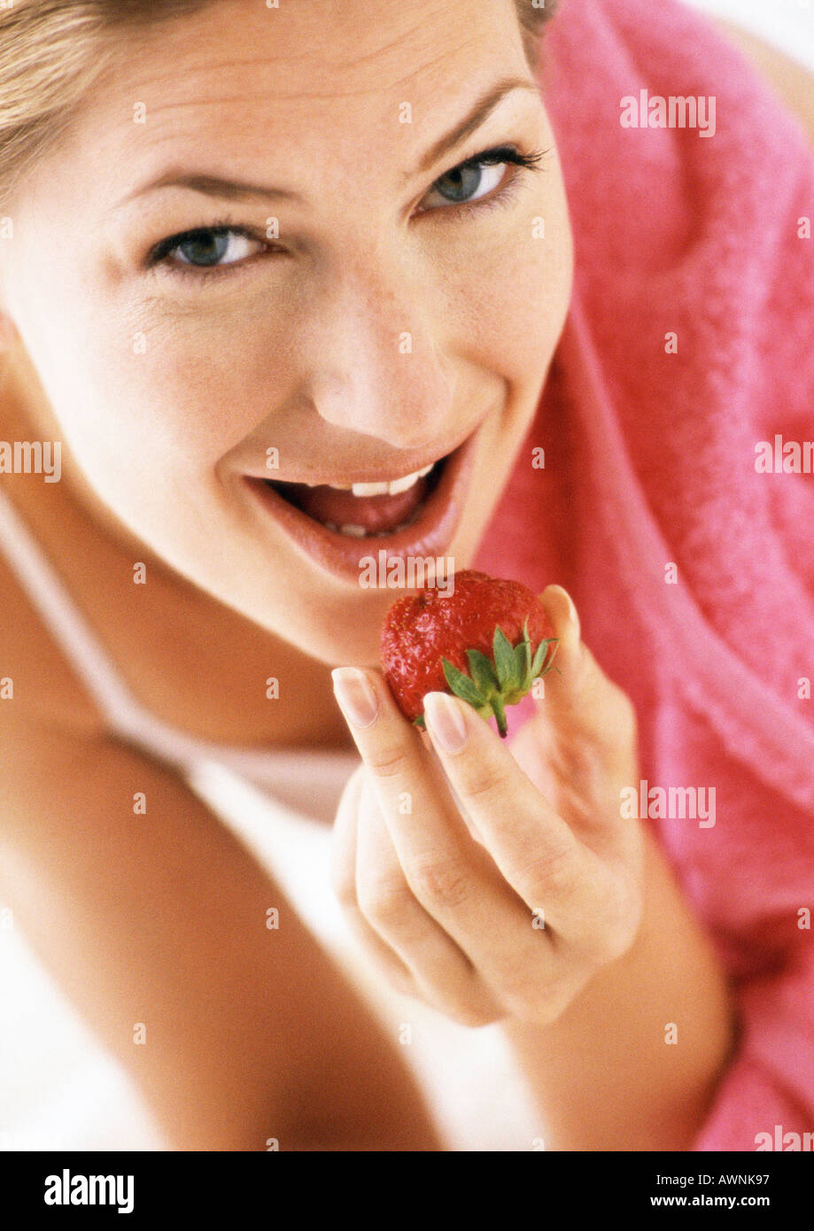 Woman eating strawberry, low angle view, close-up Stock Photo