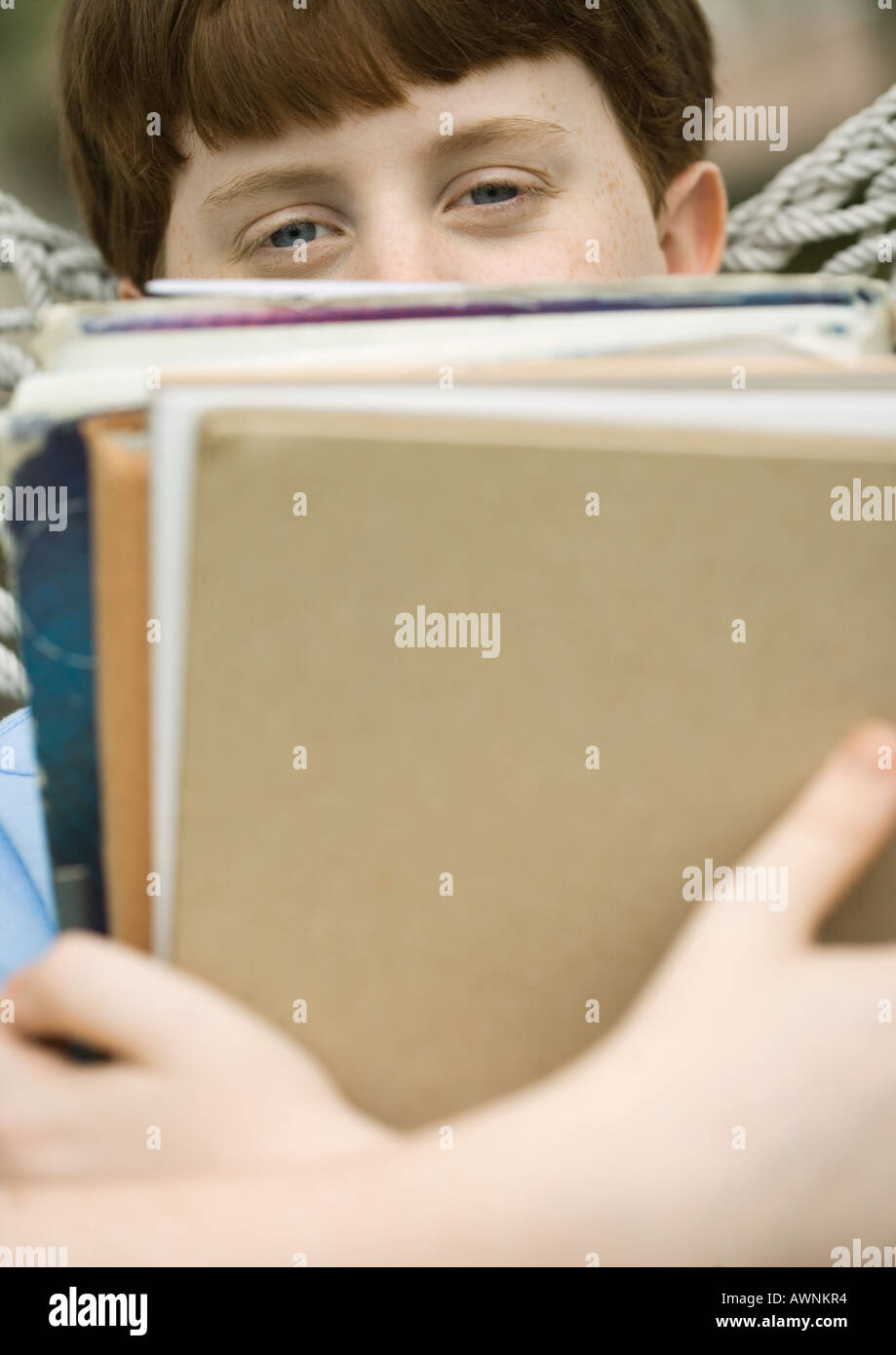 Boy holding stack of school books Stock Photo - Alamy