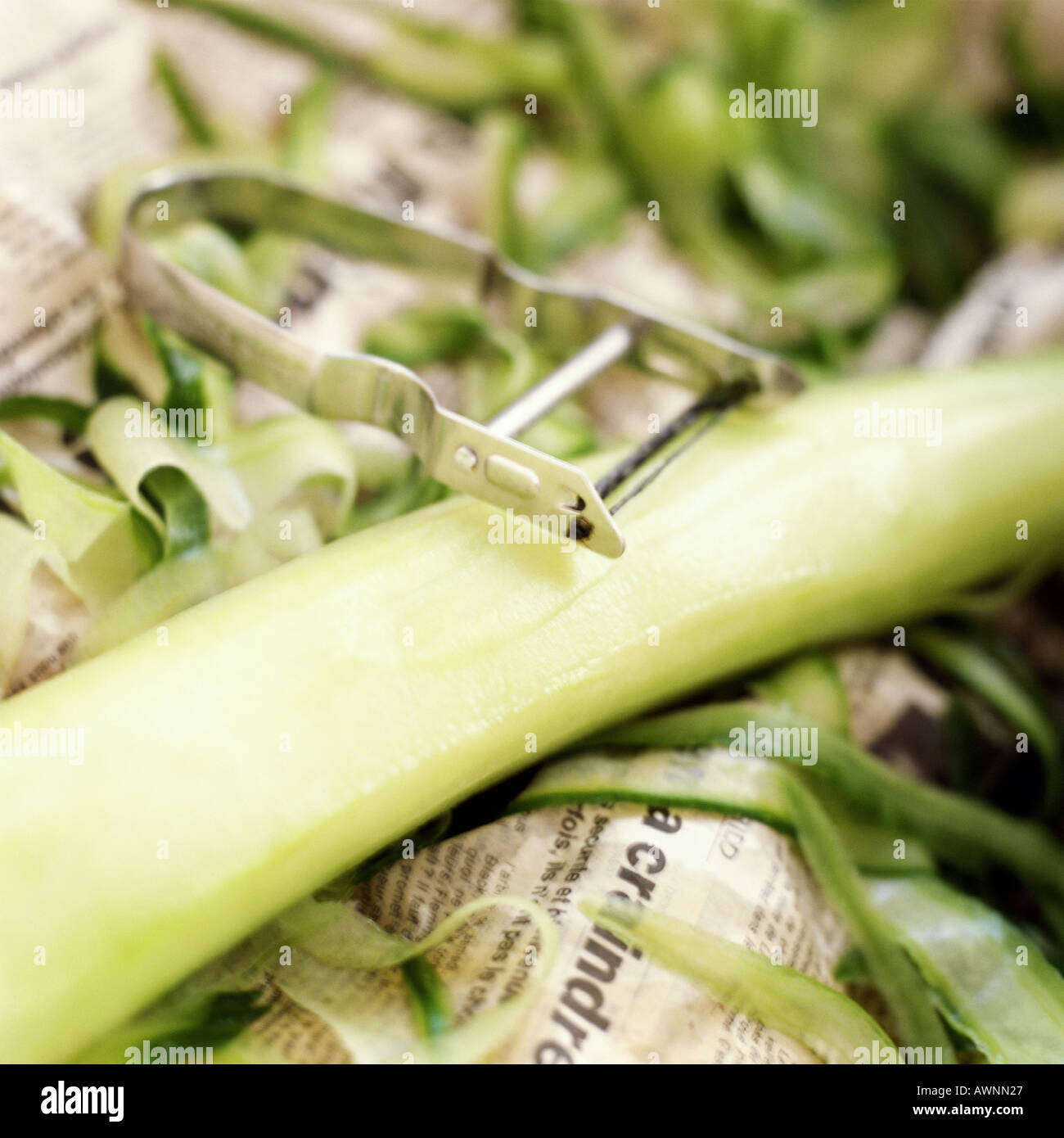 Vegetable peeler, peeled cucumber and peelings, closeup Stock Photo