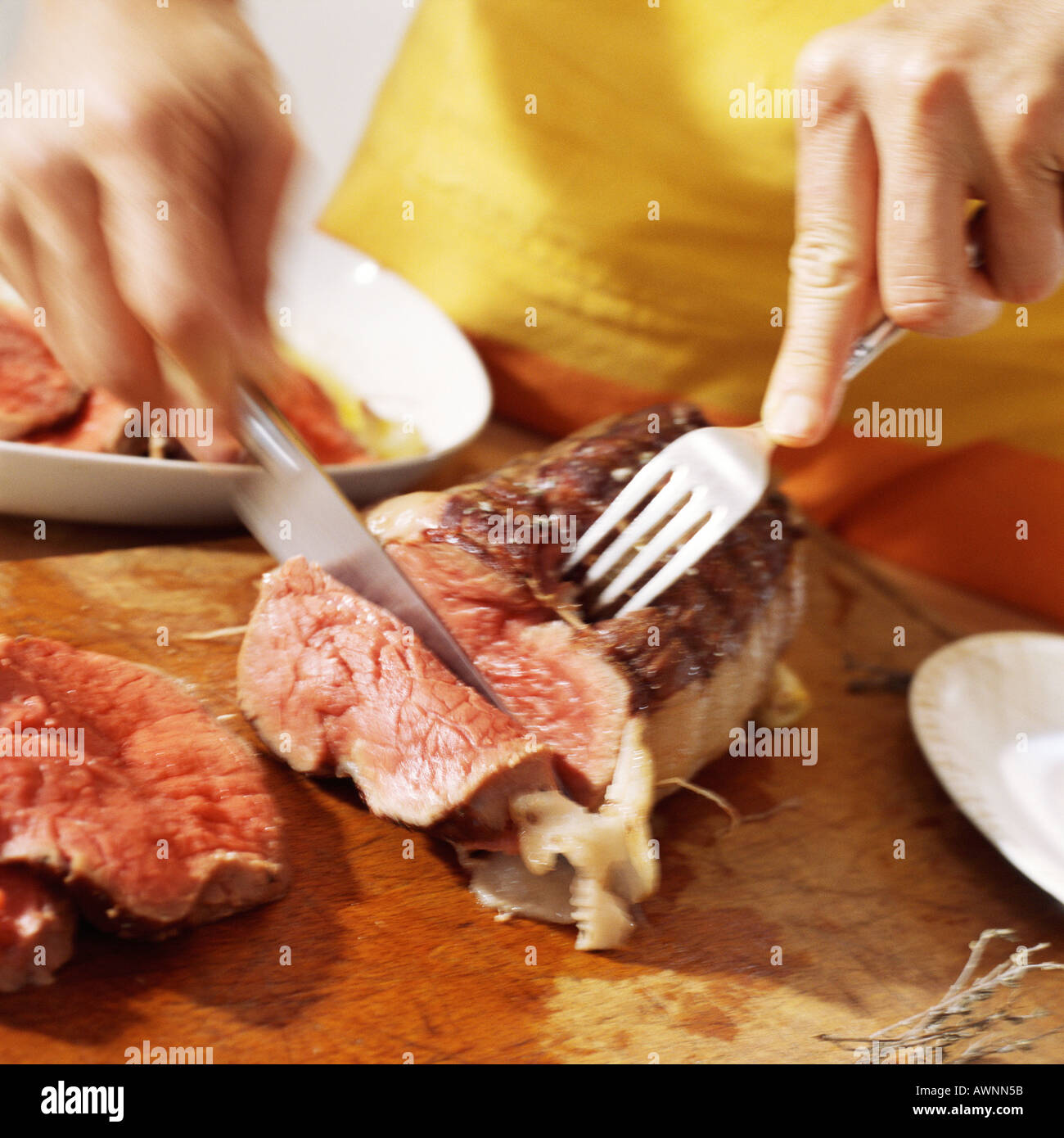 Closeup of hands cutting roast beef Stock Photo Alamy