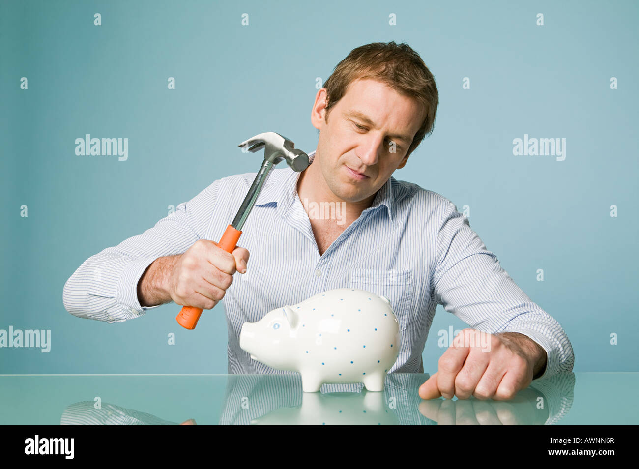 Man with hammer and piggy bank Stock Photo - Alamy