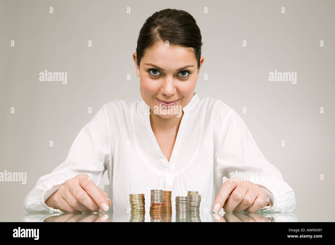 Woman with stacks of coins Stock Photo