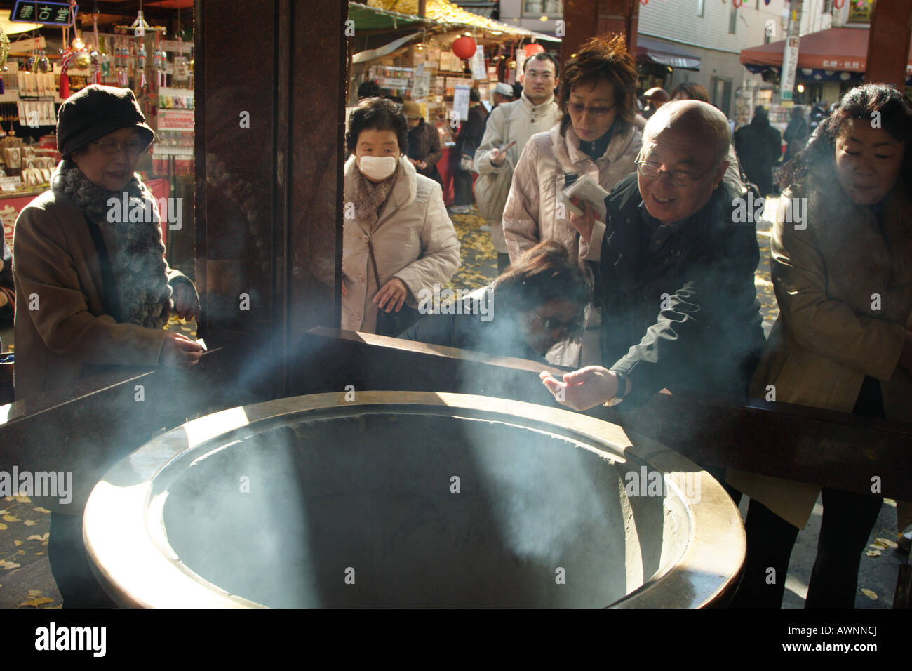 Senior citizens at an Incense burner known as a kouro at Toganji Temple Sugamo, Tokyo, Japan, Stock Photo