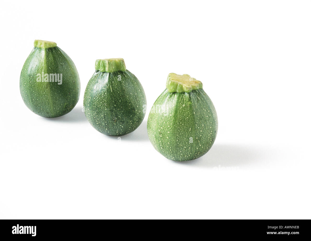 Three globe zucchini, standing on ends, in diagonal line Stock Photo