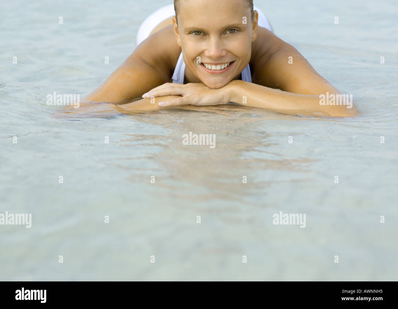 Woman lying in shallow water on beach Stock Photo - Alamy