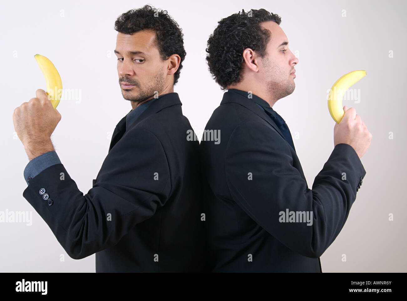 Two businessmen holding bananas as guns Stock Photo Alamy