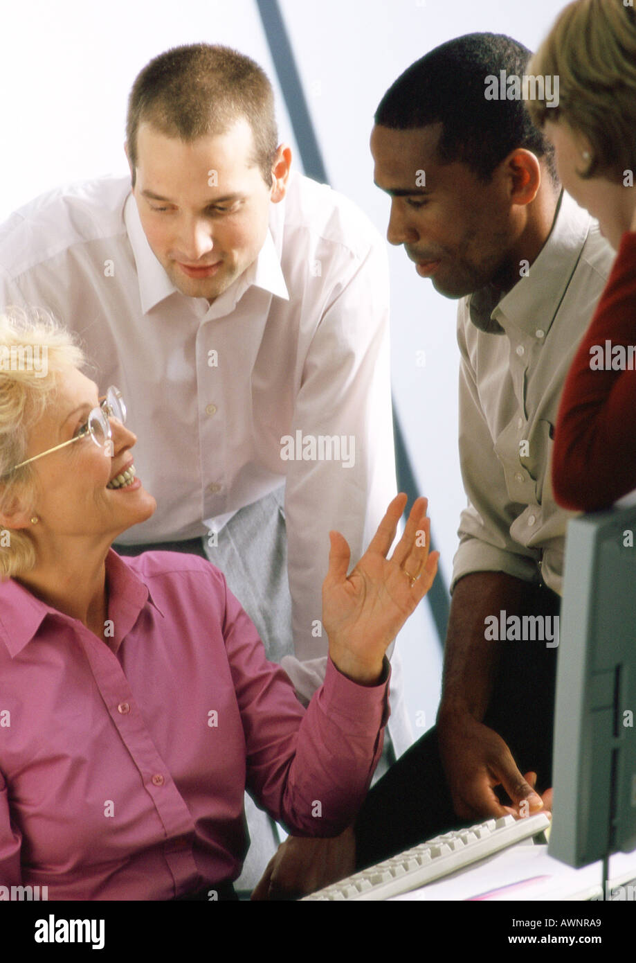 Mature businesswoman talking to other businesspeople Stock Photo
