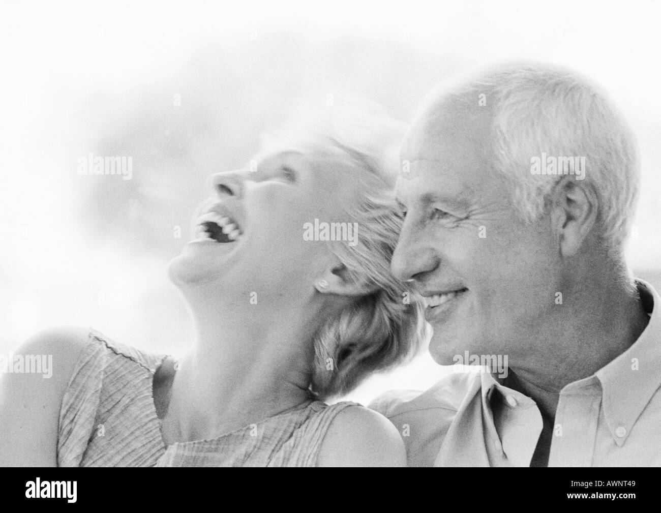 Mature man and woman smiling, woman with head back, close-up, B&W Stock Photo