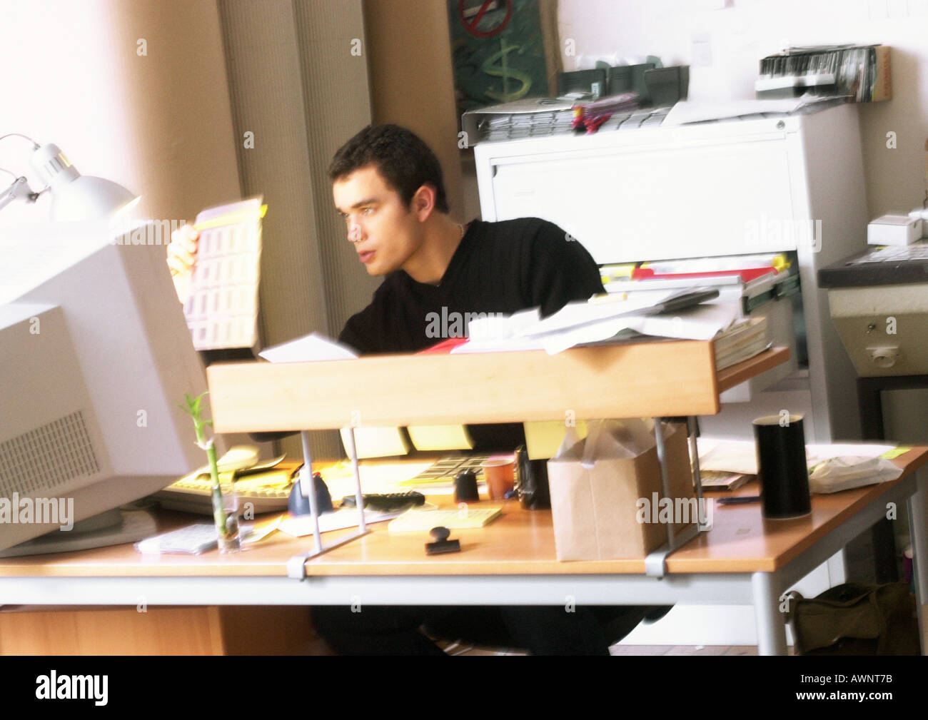 Man looking at slides, sitting at desk Stock Photo