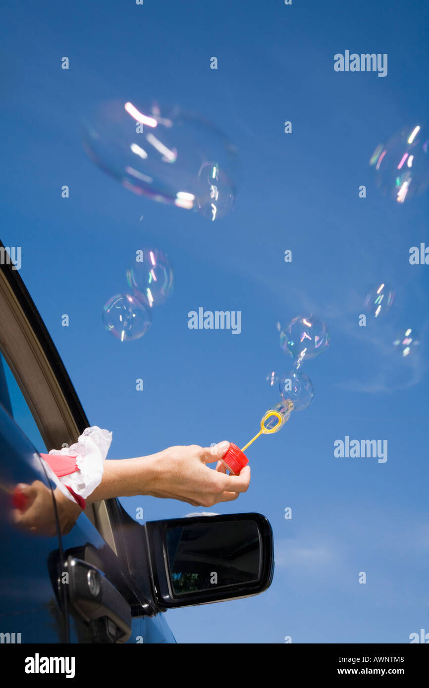 Woman blowing bubbles out car window Stock Photo Alamy