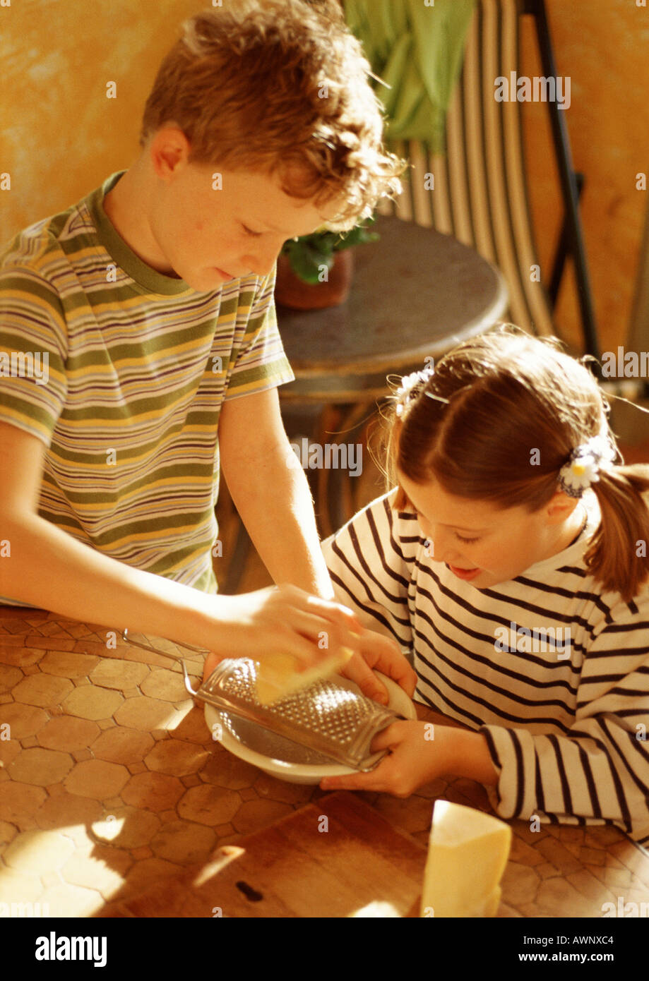 Two children grating cheese Stock Photo Alamy