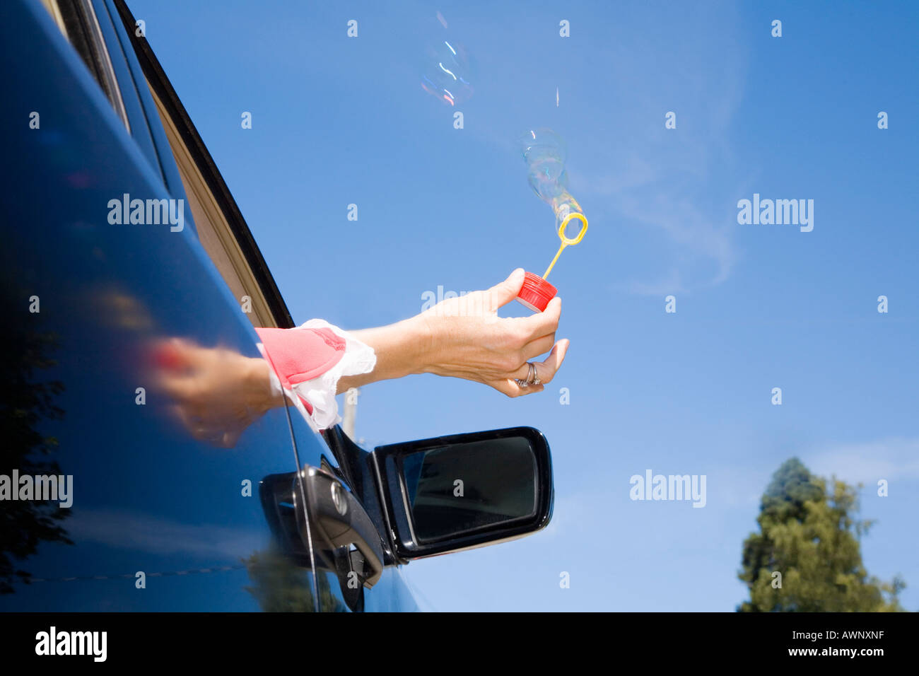 Woman blowing bubbles out car window Stock Photo Alamy