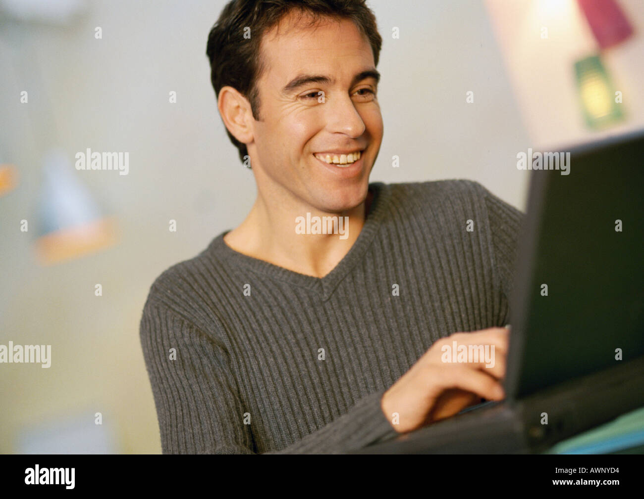 Man using laptop computer, smiling, close-up Stock Photo